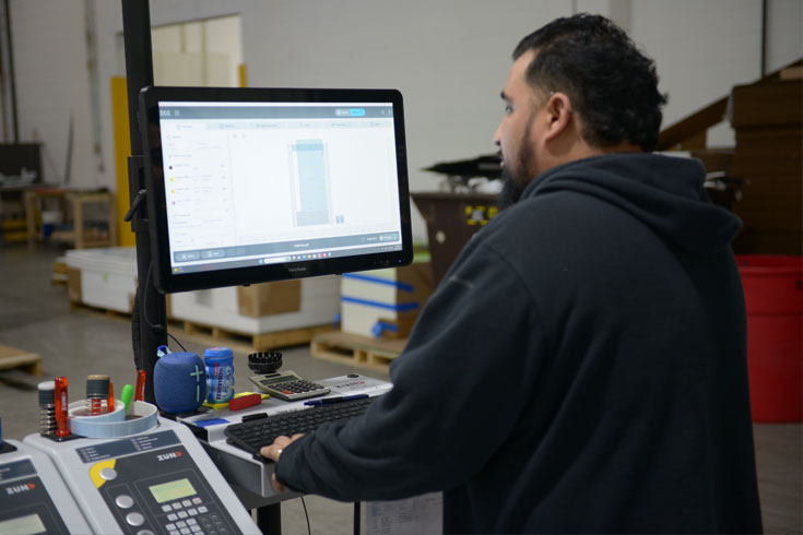 Technician using Zünd Cut Center software to manage a precision digital cutting job at Infused Color Graphics.