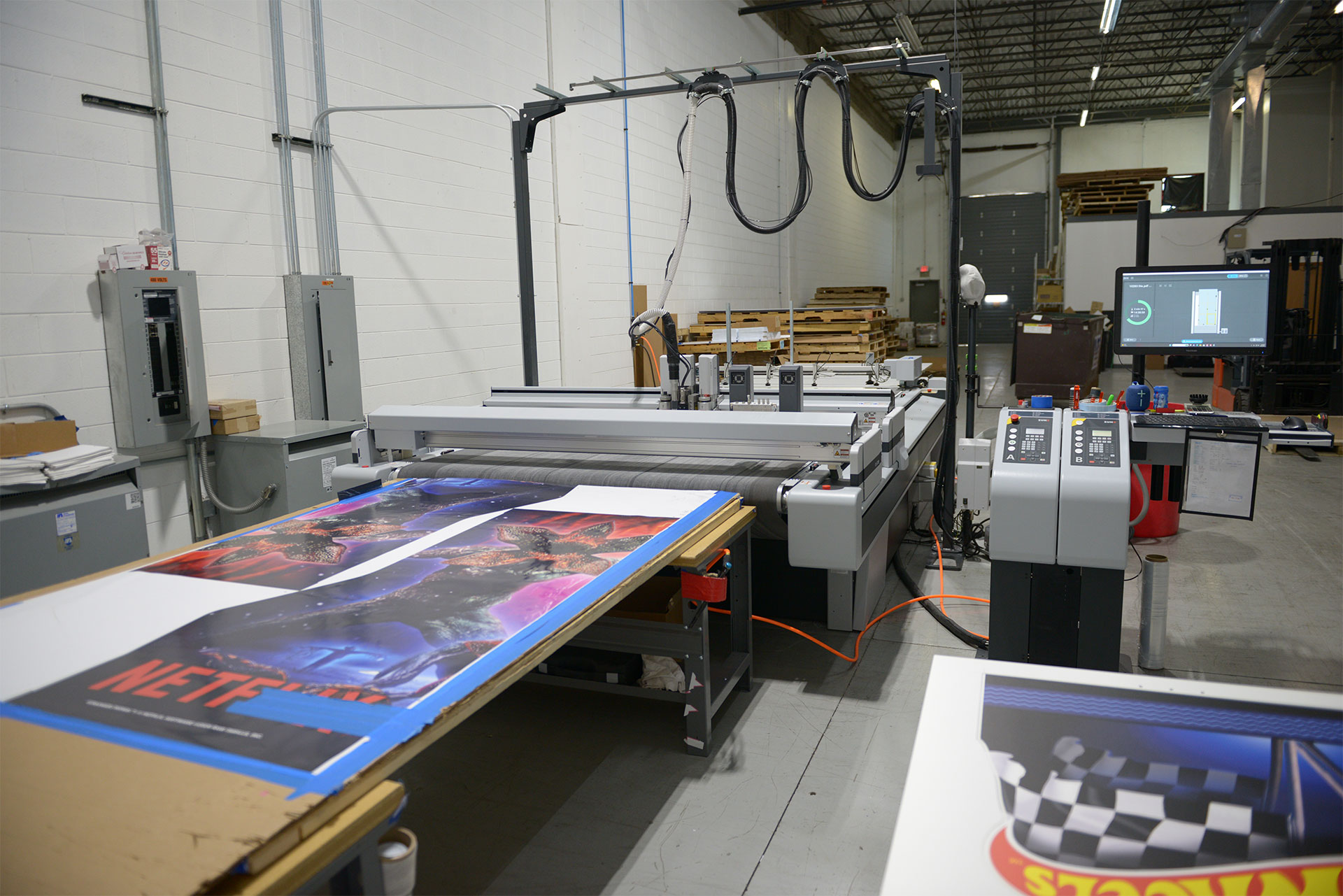 A Digitech UV flatbed printer and Zünd digital cutting system operating in the Infused Color Graphics facility.
